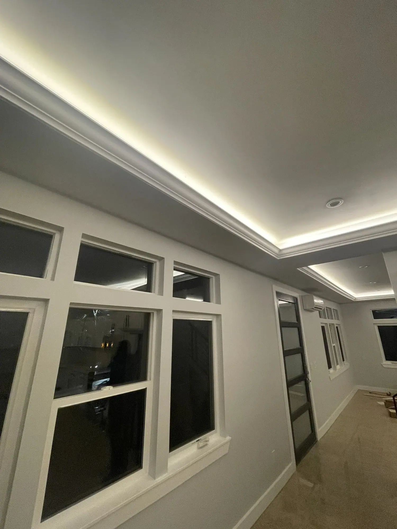 Hallway with an LED cove ceiling and windows on the main level
