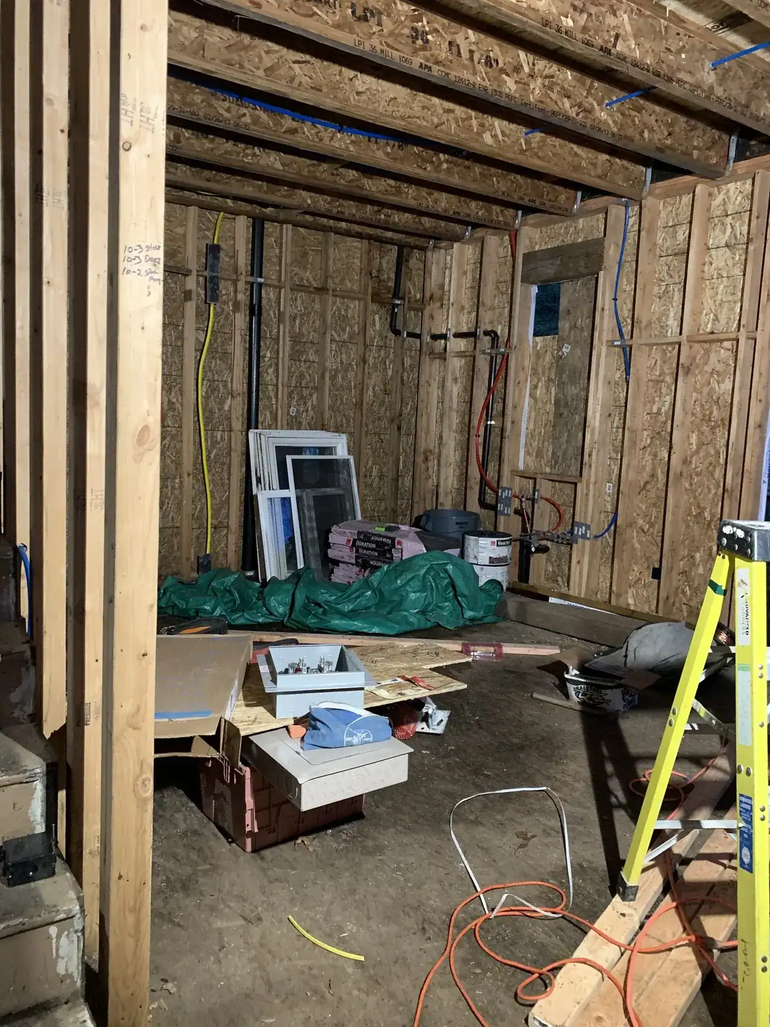 Framing with exposed beams and OSB sheathing on the upper floor