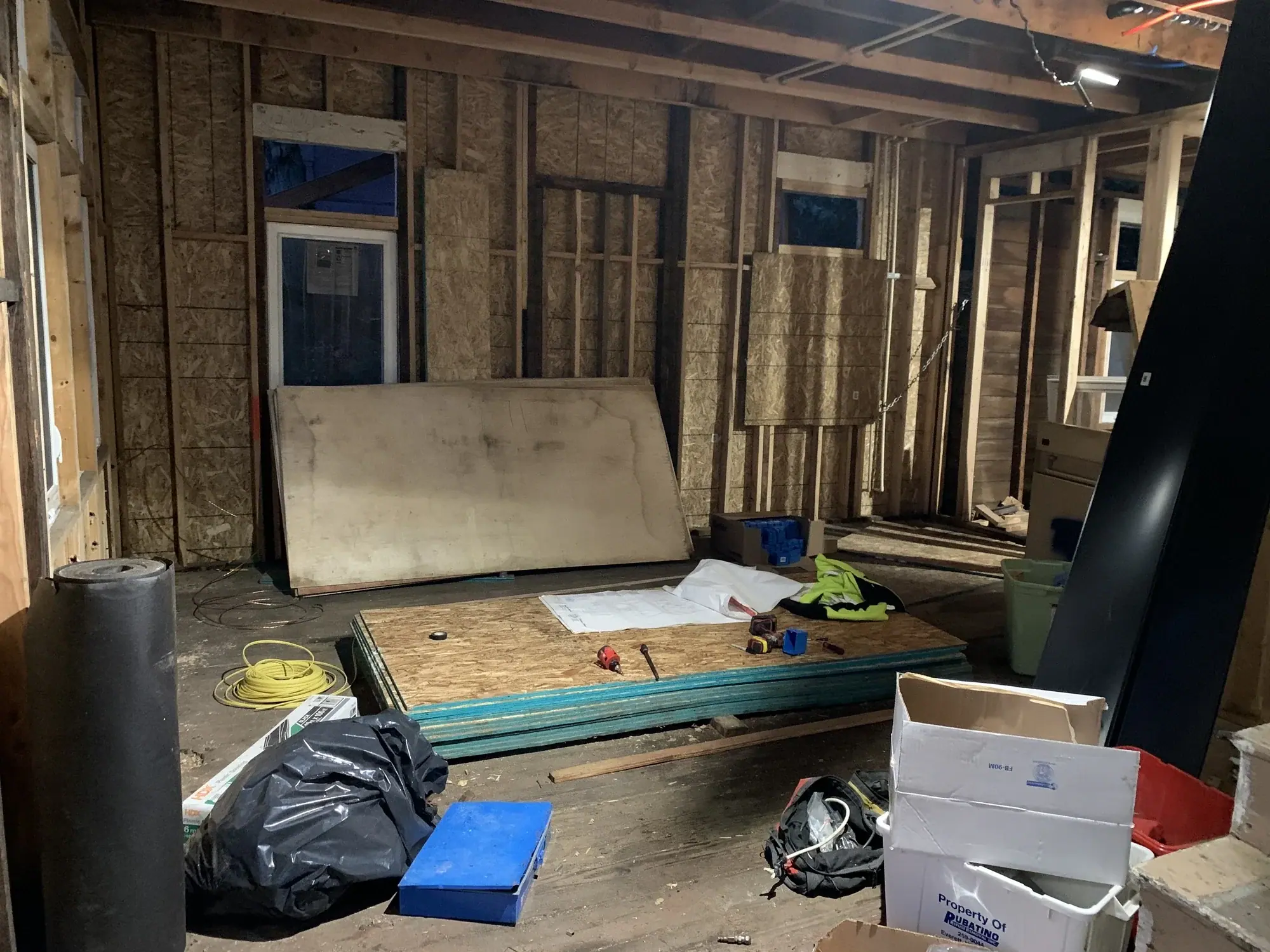 Framed room with sheathing and materials staged before insulation
