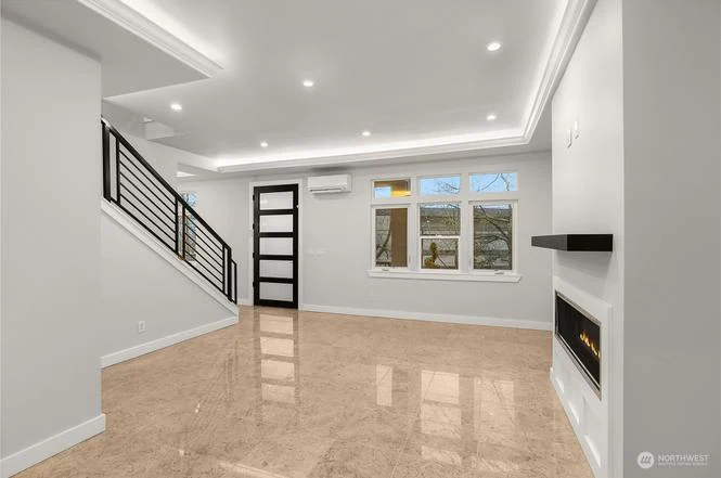Living room with the open stair, linear fireplace, and LED tray ceiling