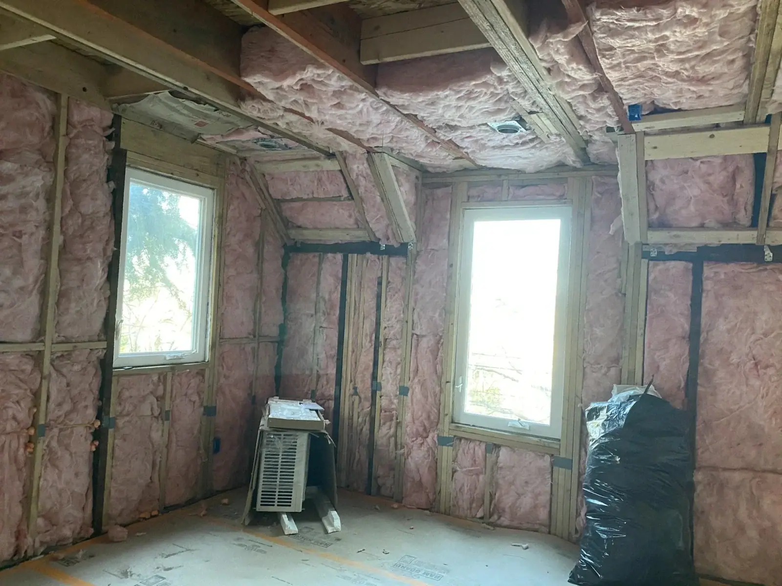 Insulated bedroom with two windows ahead of drywall