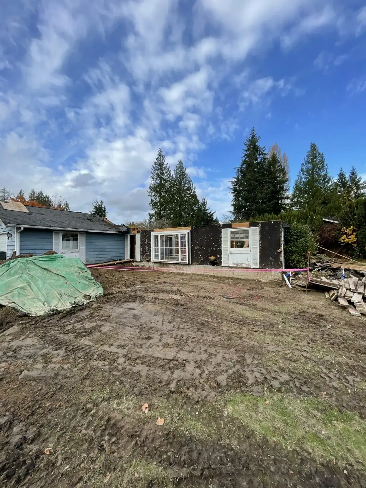 Before: the original blue rambler and detached shed on the dirt lot ahead of demolition