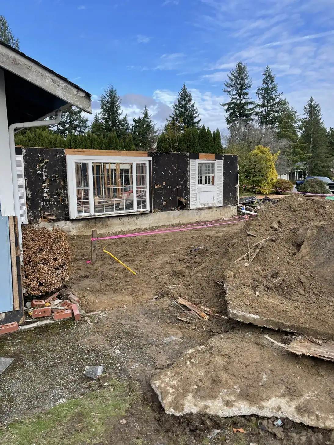 Cleared lot with the remaining shed walls, excavation, and layout string lines