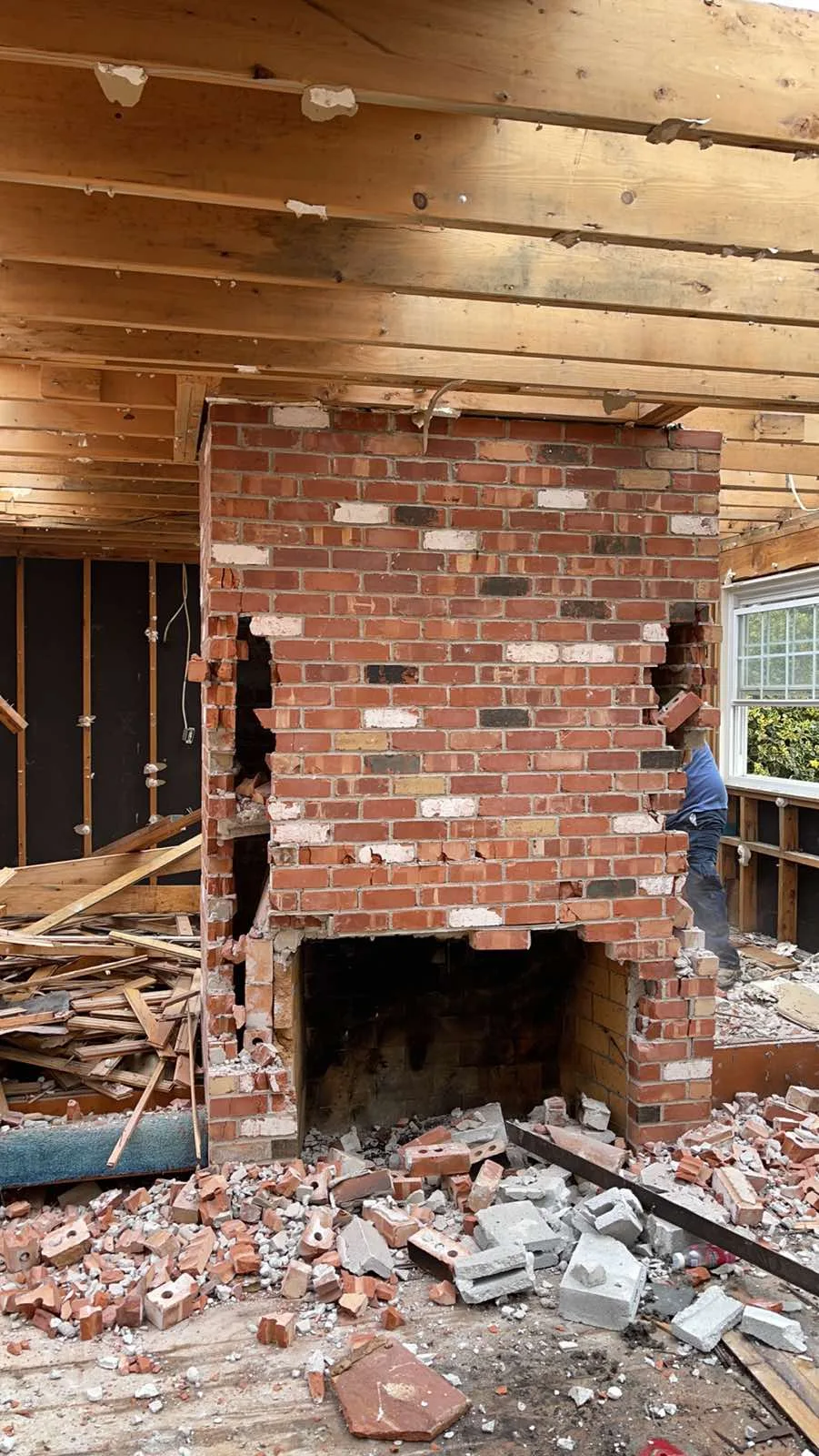 Brick fireplace and chimney exposed inside the old rambler during demolition