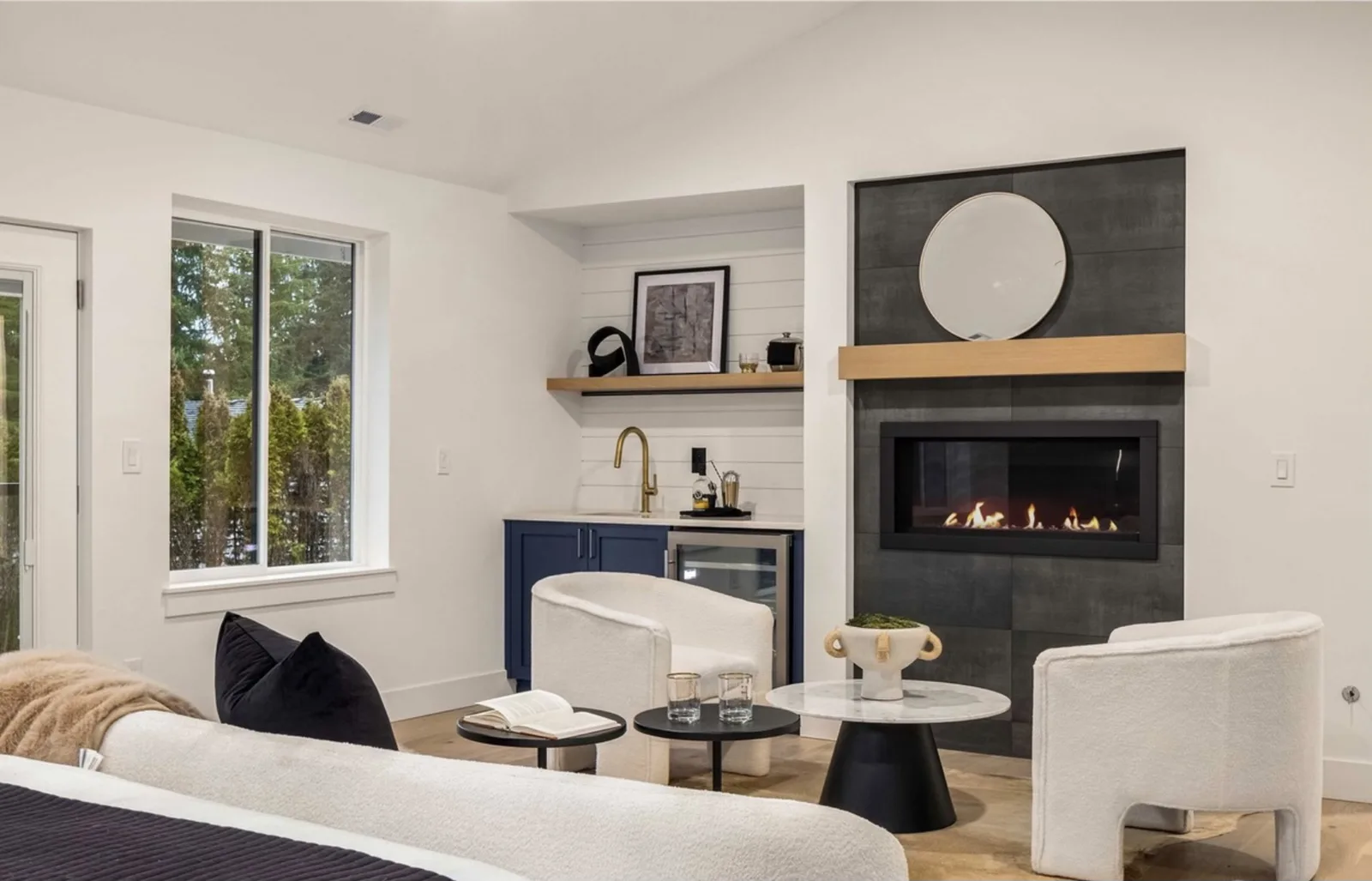 Sitting room with a tile-surround fireplace, wood mantel, and a navy wet bar