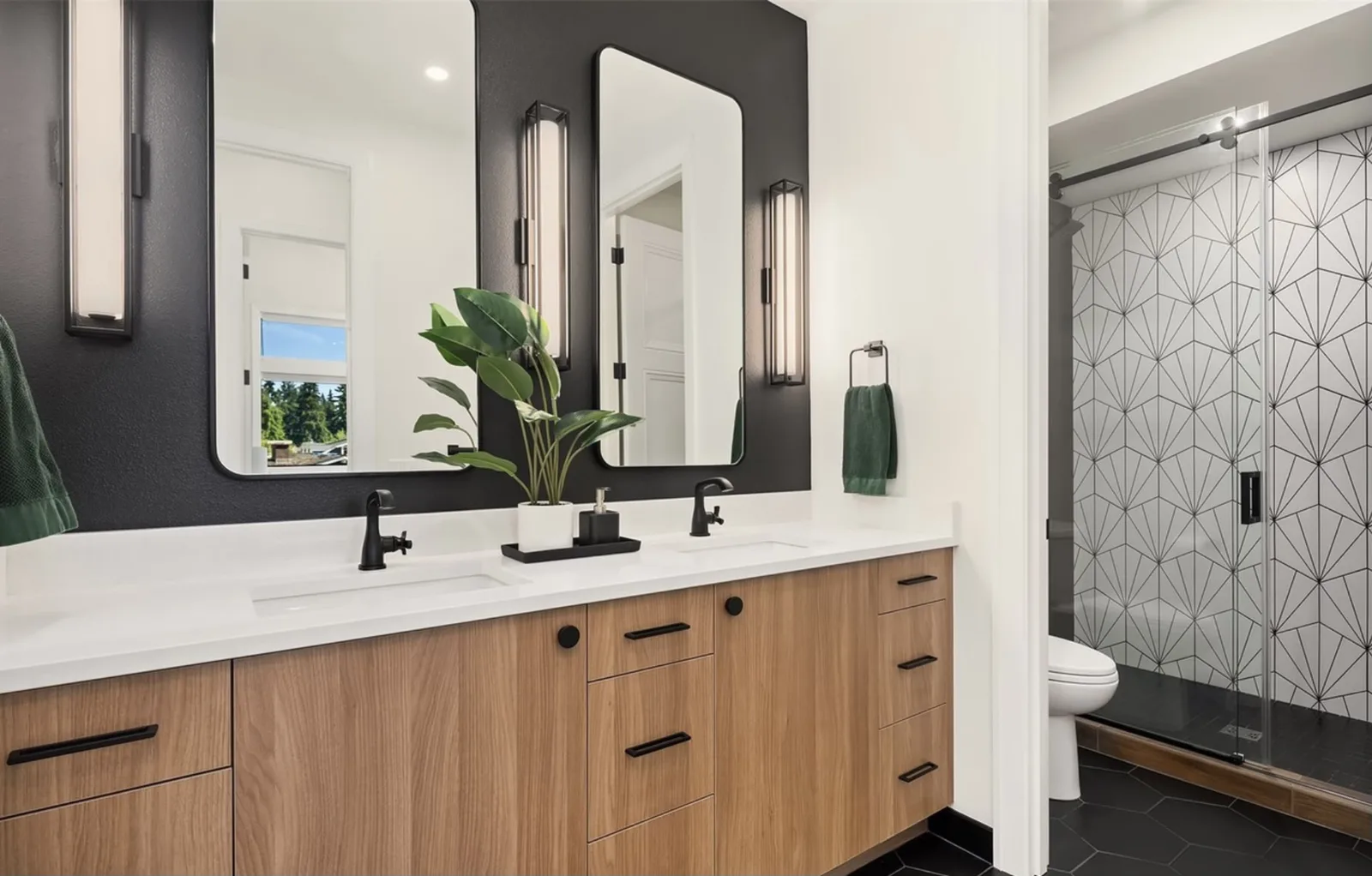 Bathroom with a floating walnut vanity, black accent wall, black fixtures, and a patterned tile shower