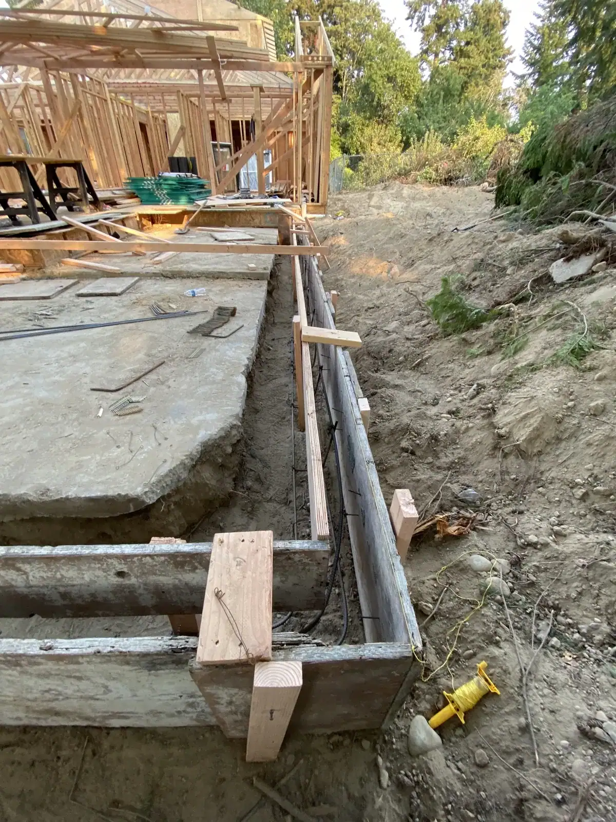 Footing form corner with rebar and a drain line set