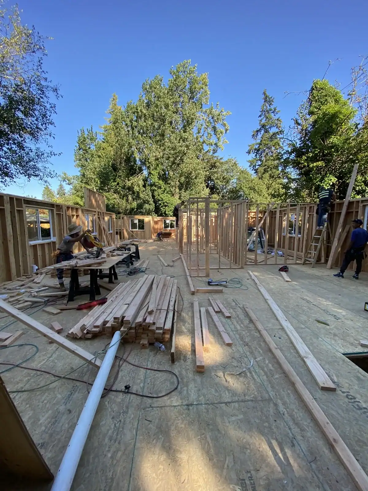 Framed walls with lumber stacked on the subfloor