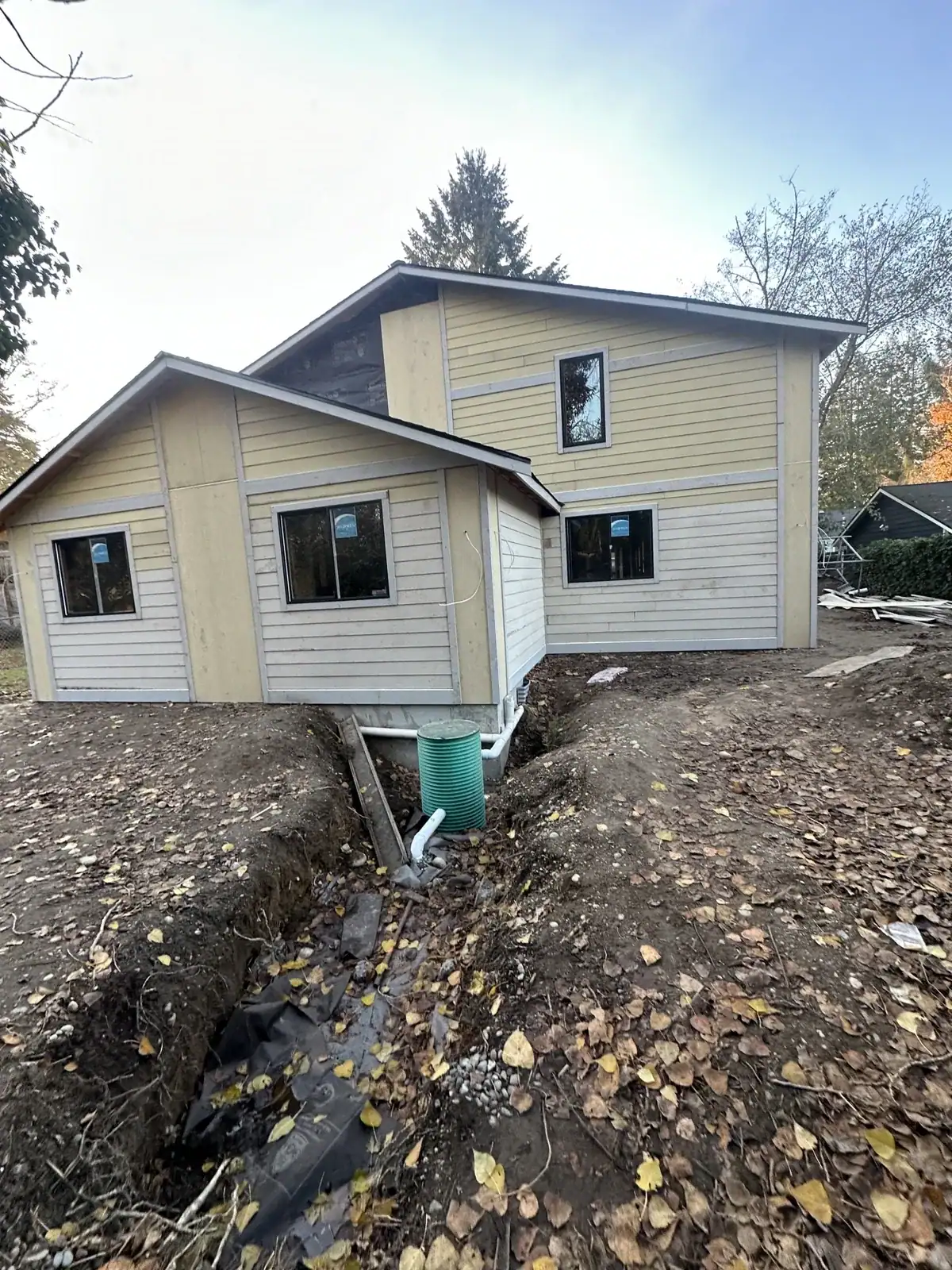 Primed fiber-cement lap siding going up on the exterior before paint