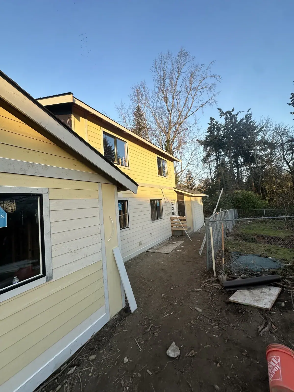 Side elevation with primed lap siding and windows installed