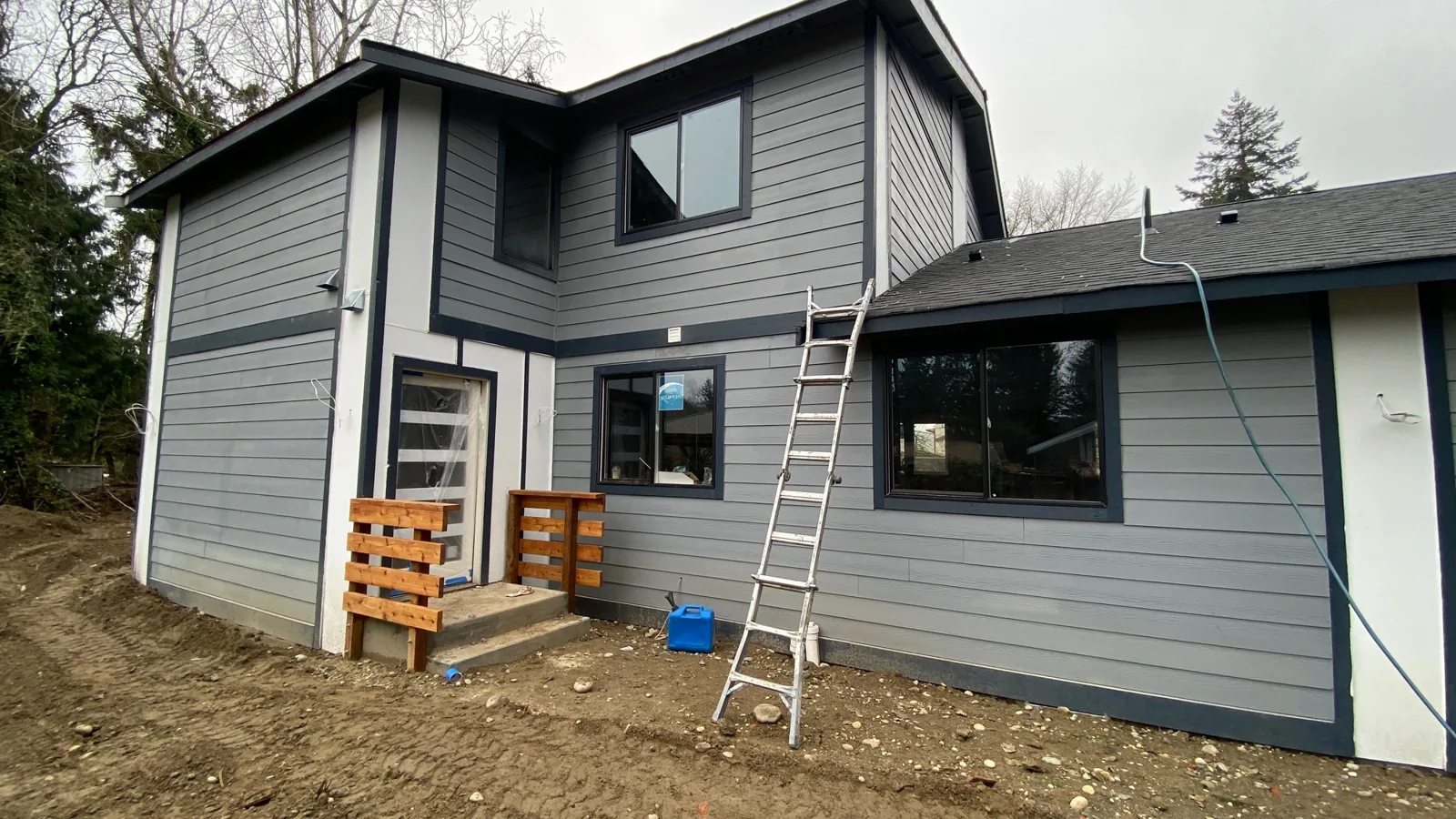 Rear of the finished home in two-tone gray-blue fiber-cement siding