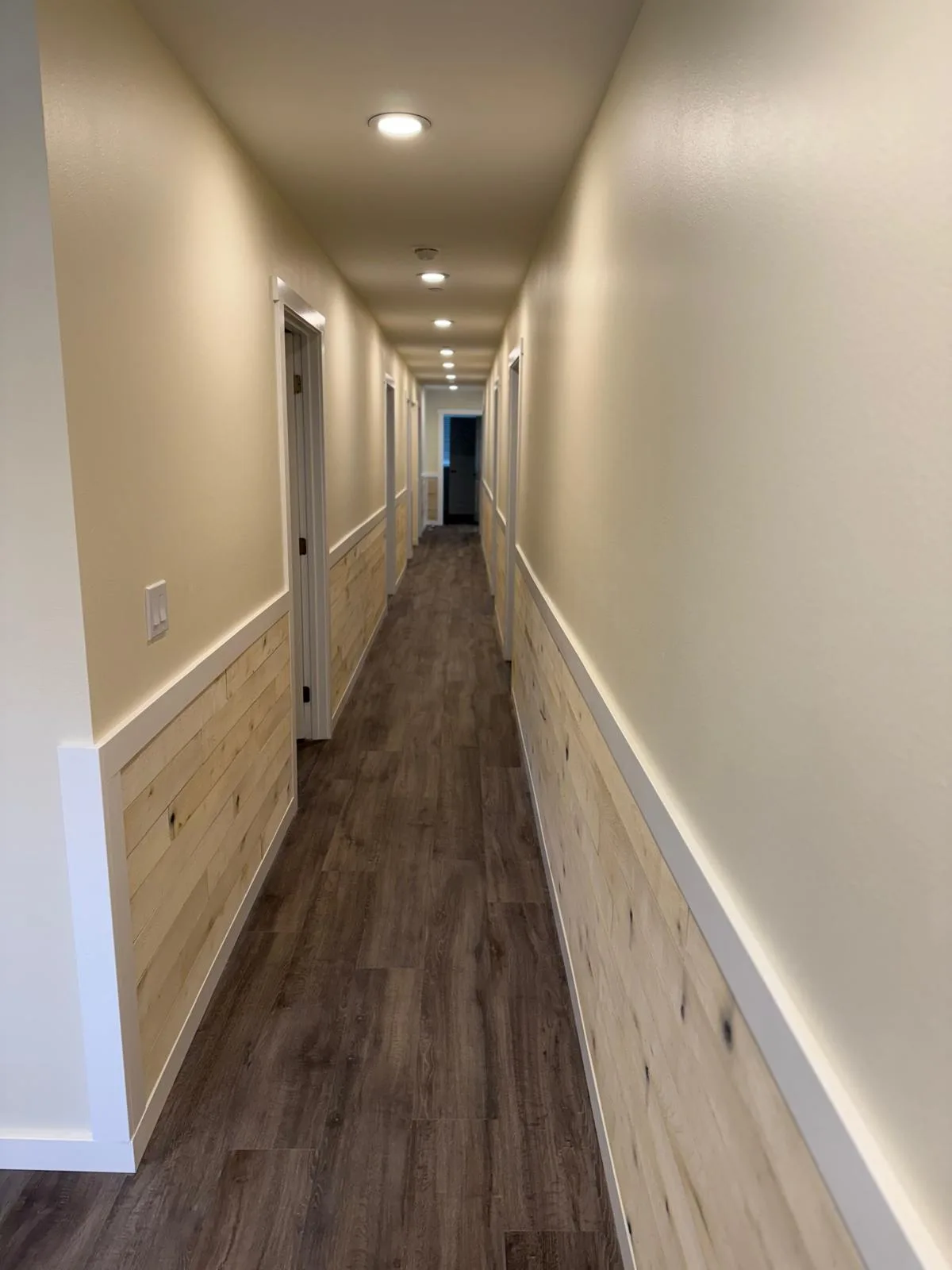 Long hallway with shiplap wainscot and LVP flooring