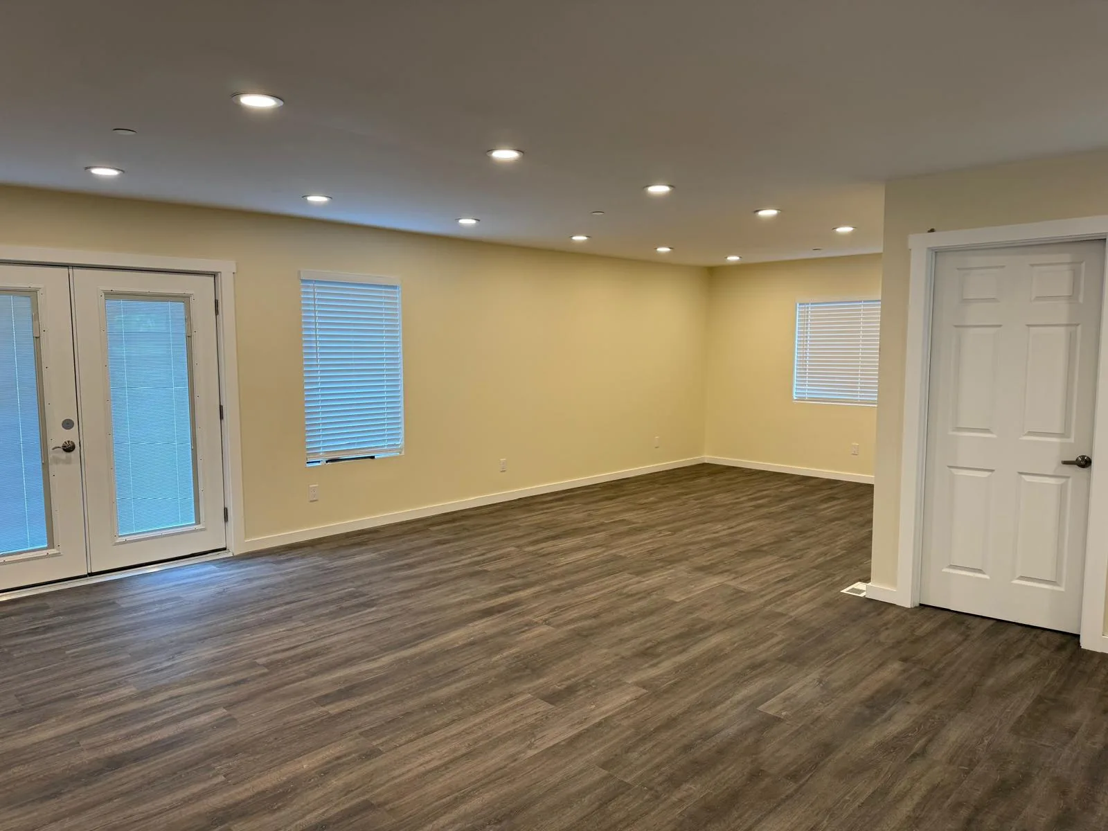 Living room with French doors, recessed lighting, and LVP flooring