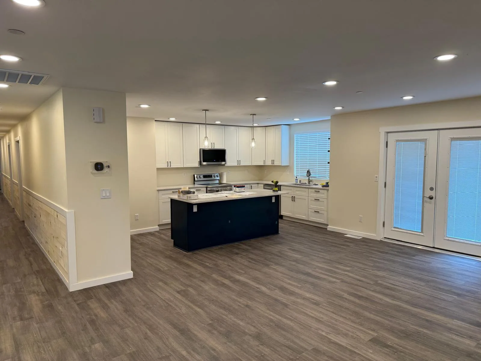 Kitchen with a navy island, white shaker cabinets, and stainless appliances