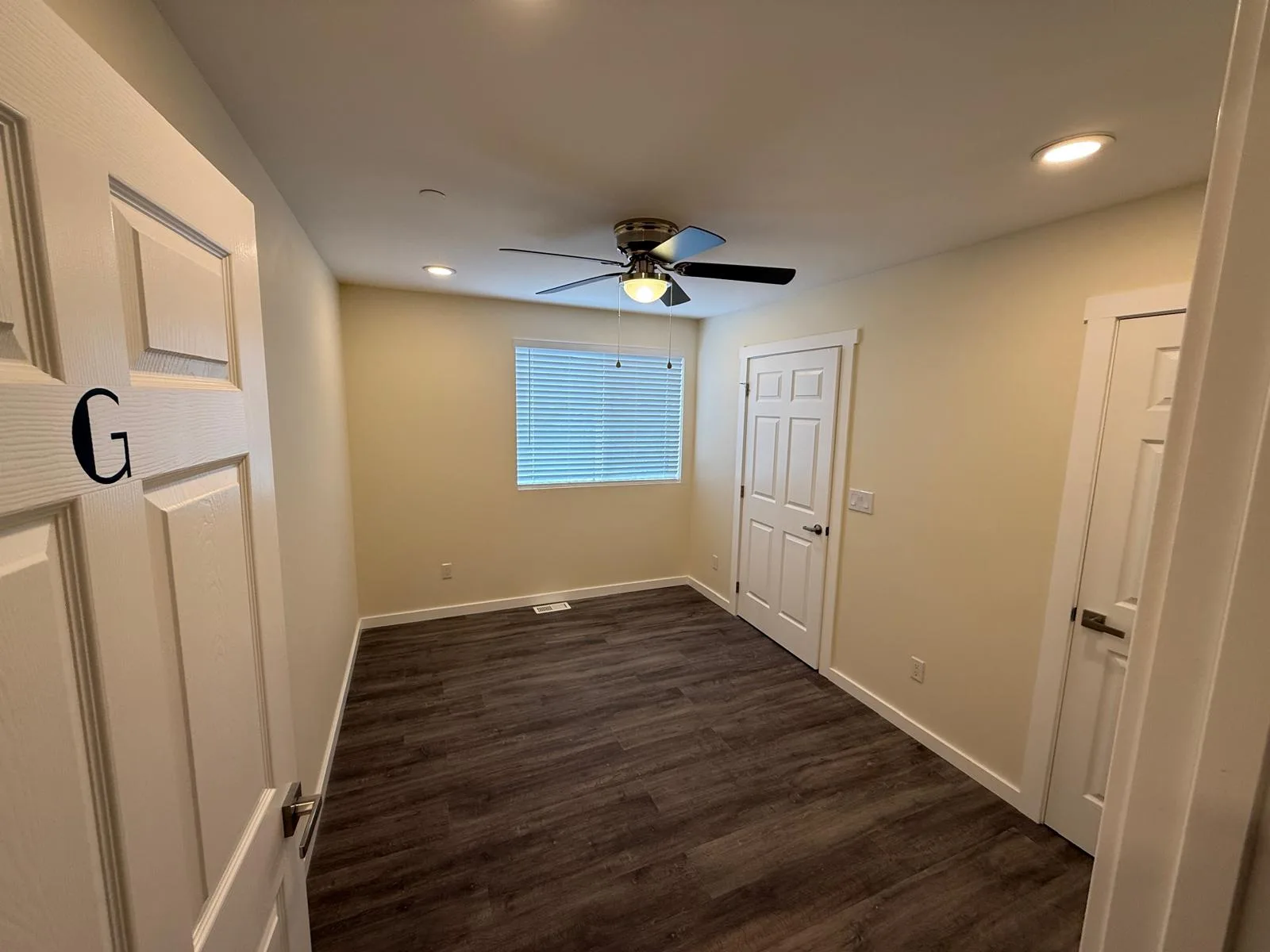 Bedroom with a ceiling fan, window, and LVP flooring