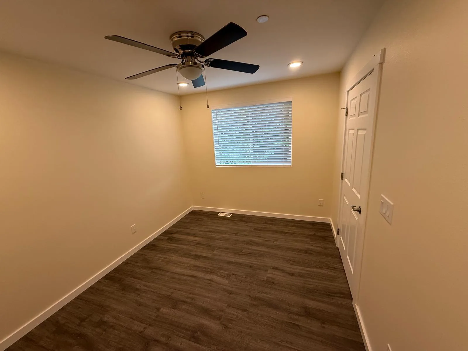 Bedroom with a ceiling fan and blinds on the window