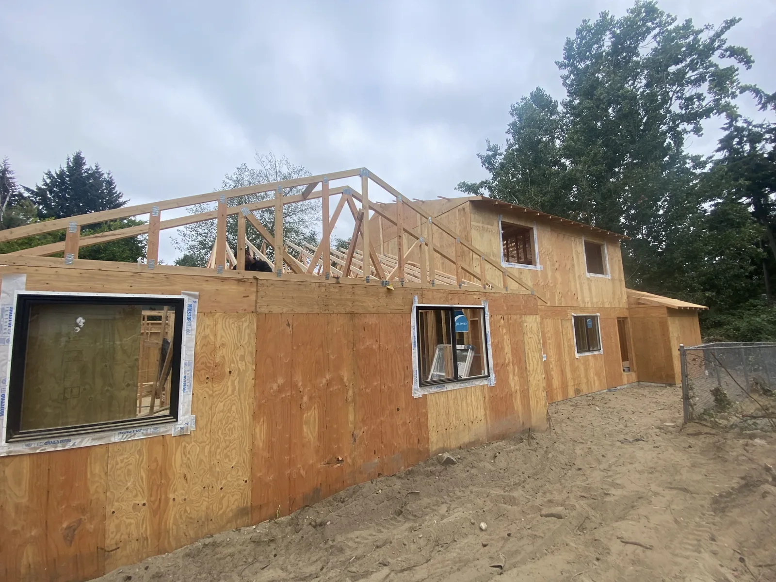Sheathed exterior walls with roof trusses being set