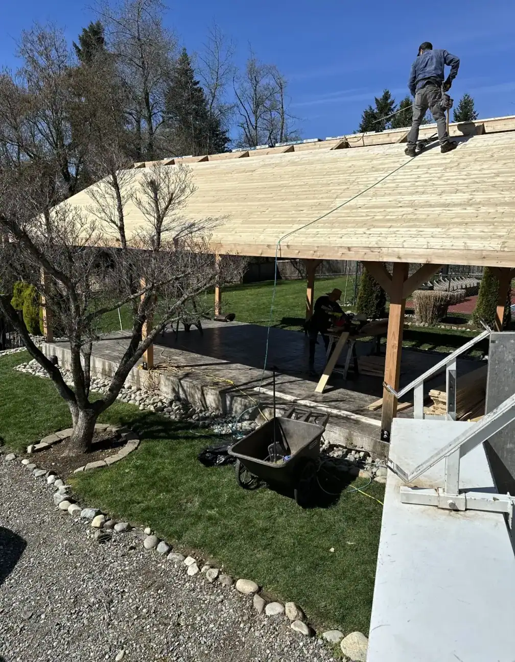 Crew member on the roof installing sheathing over the trusses