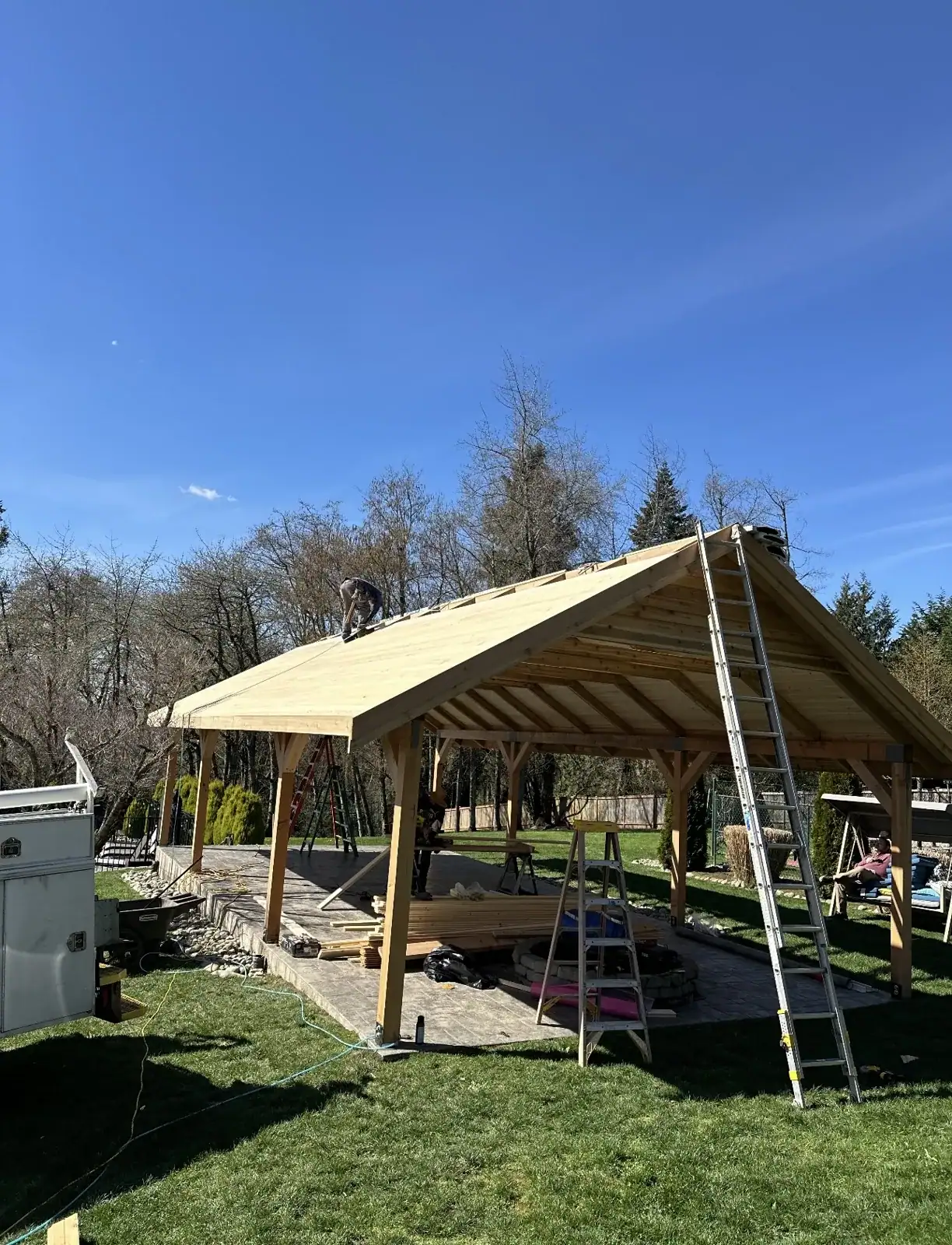 Roof sheathing complete on the pavilion frame, ladders still in place