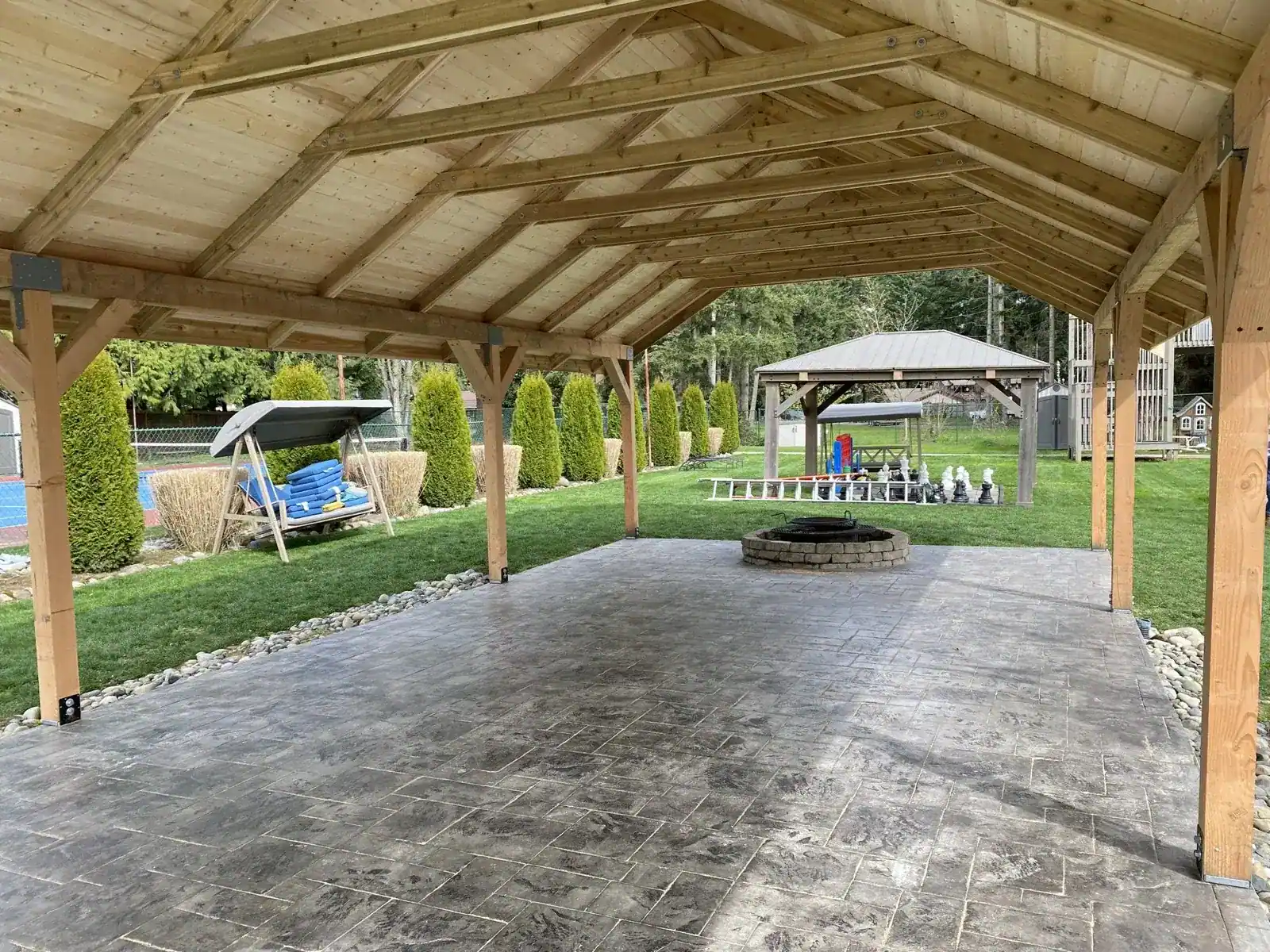 Looking out from inside the pavilion past the fire pit to the lawn