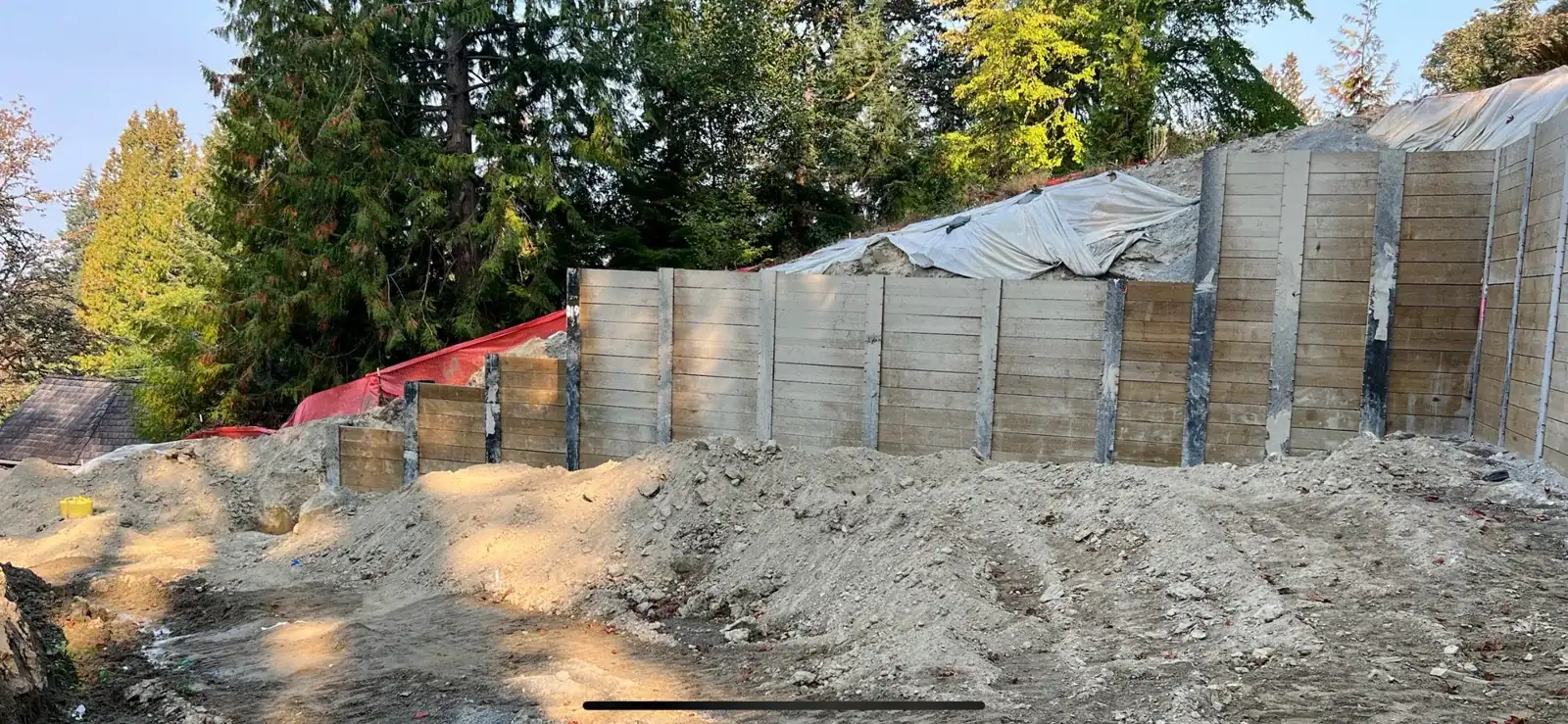 Soldier-pile wall stepping down the hillside in tiers above the graded pad