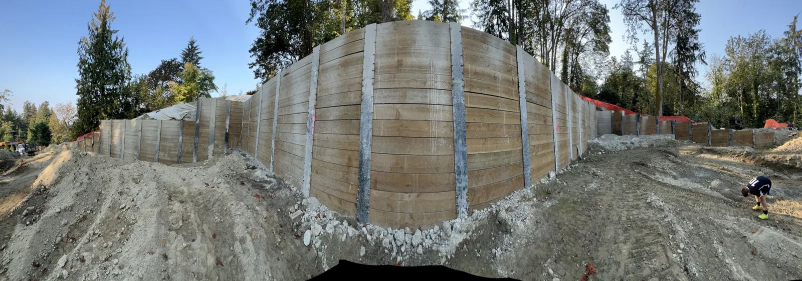 Panoramic view of the finished soldier-pile wall with drain rock along its base
