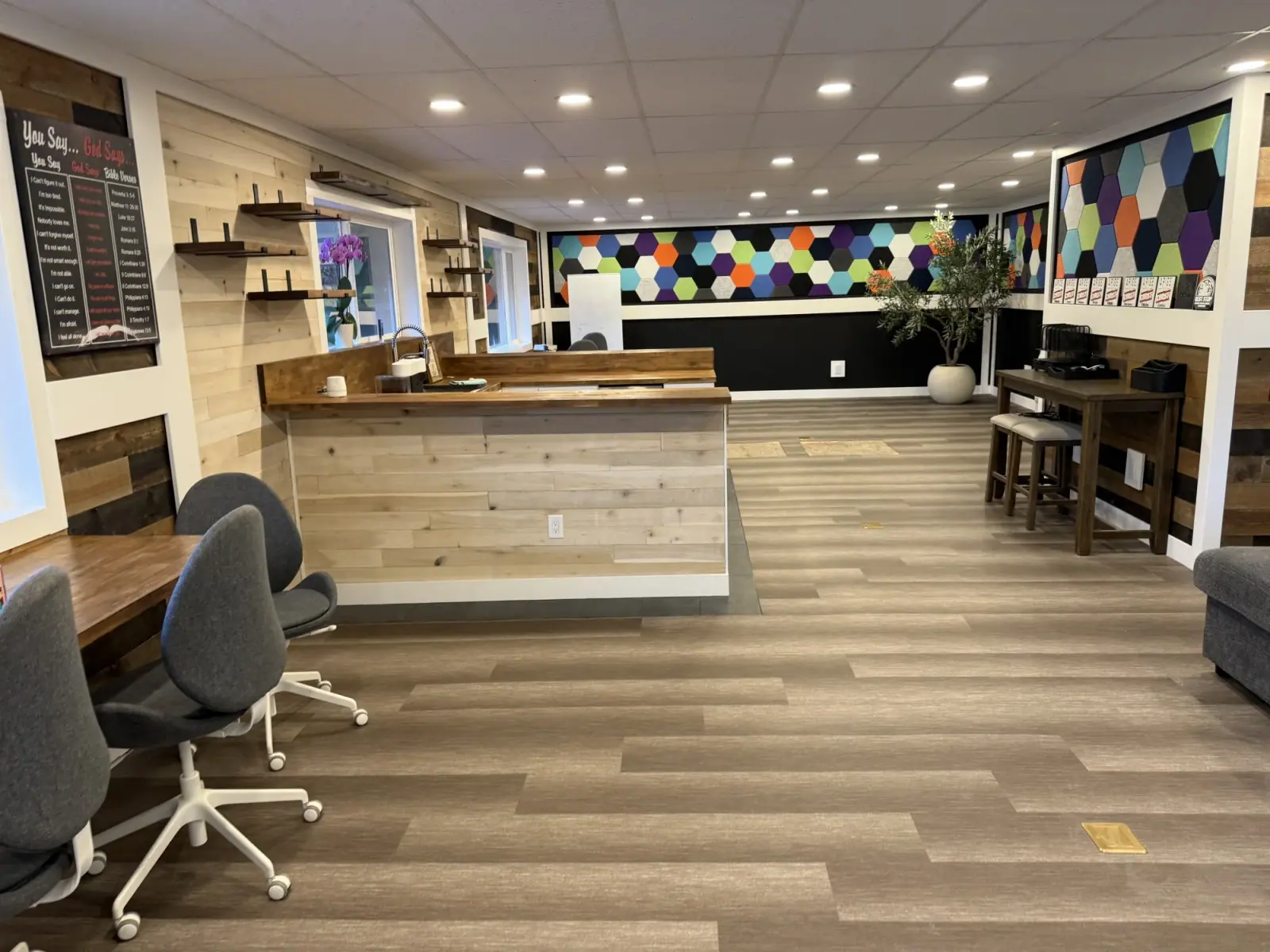 Finished workspace with butcher-block counters, reclaimed-wood walls, hex acoustic panels, and desk chairs