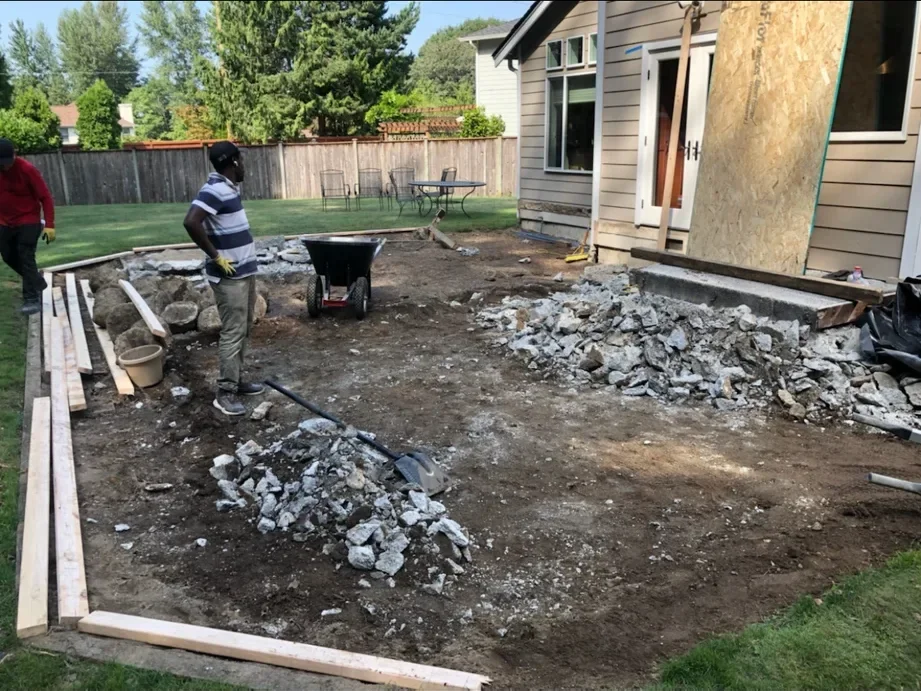 Crew breaking out the old concrete slab into rubble beside the back door