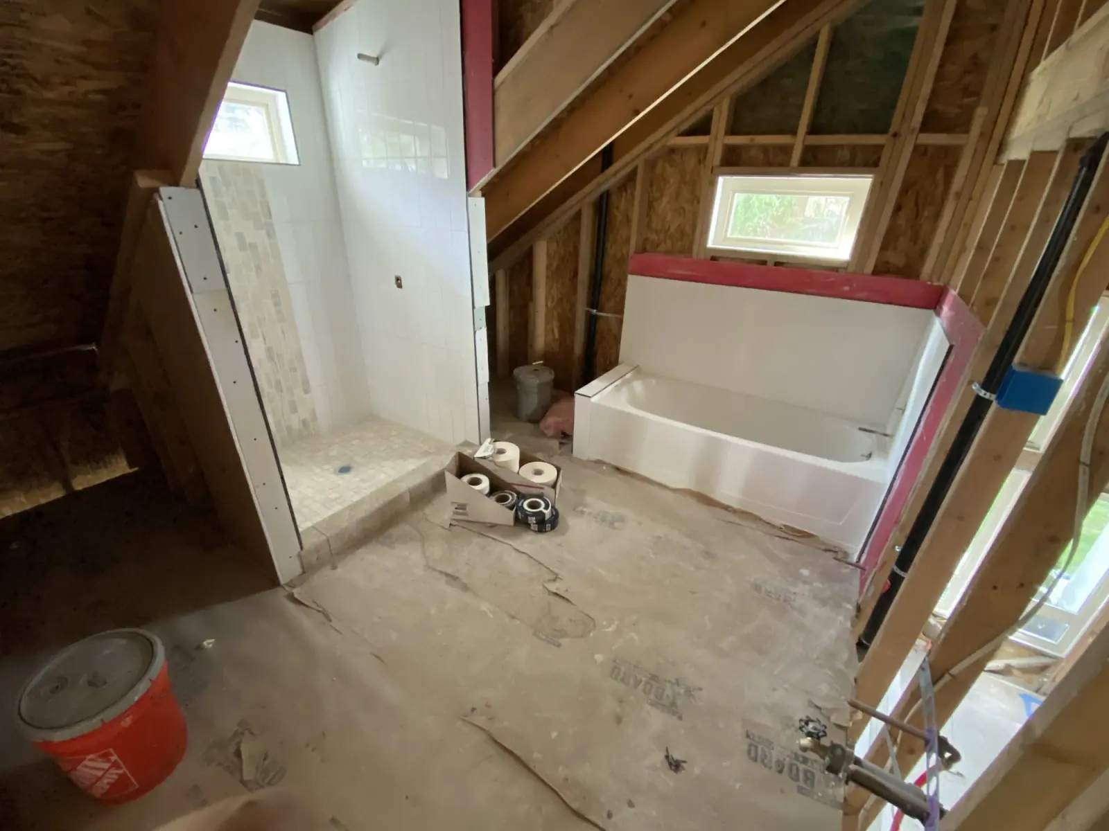 Bathroom rough-in with the tub set, shower niche framed, and PEX supply lines stubbed