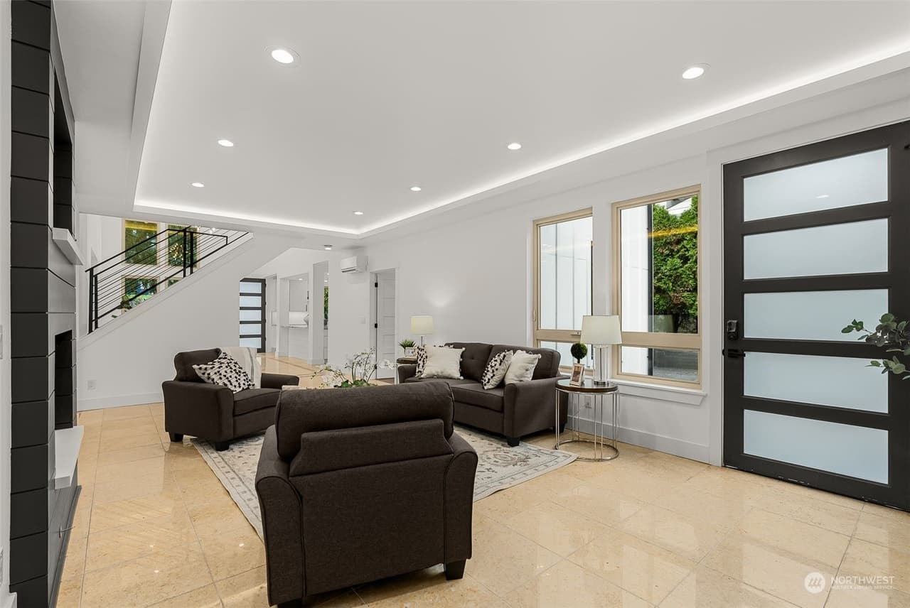 Living room with a sectional, LED-lit tray ceiling, and a glass door to the yard