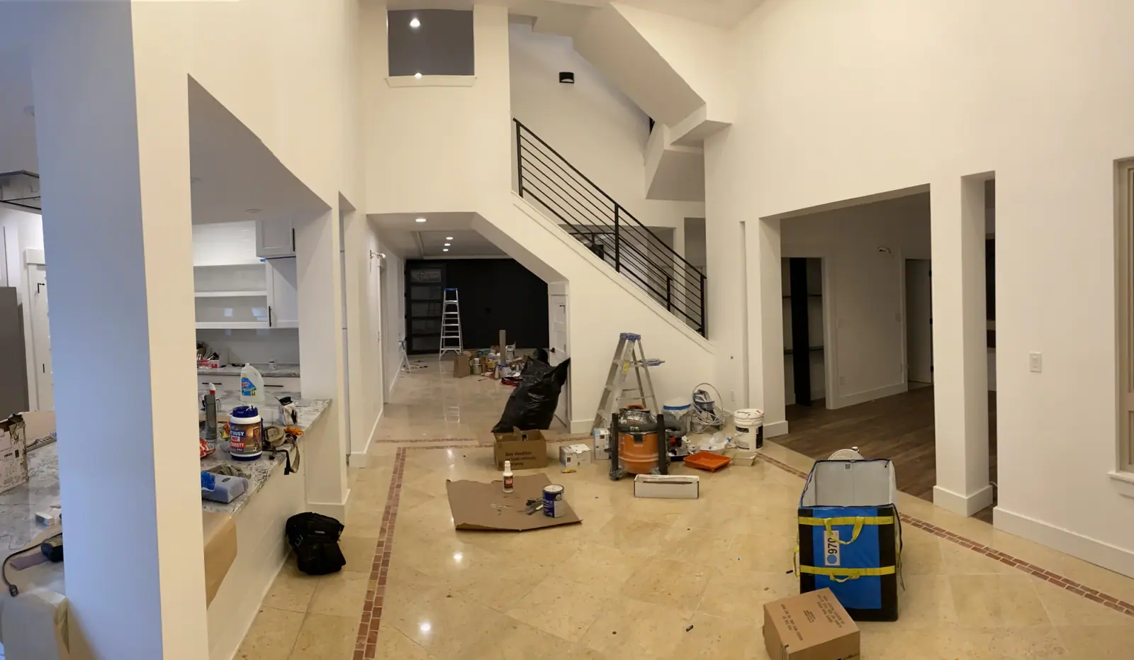 16-foot foyer with the black-railed stair during final finish work