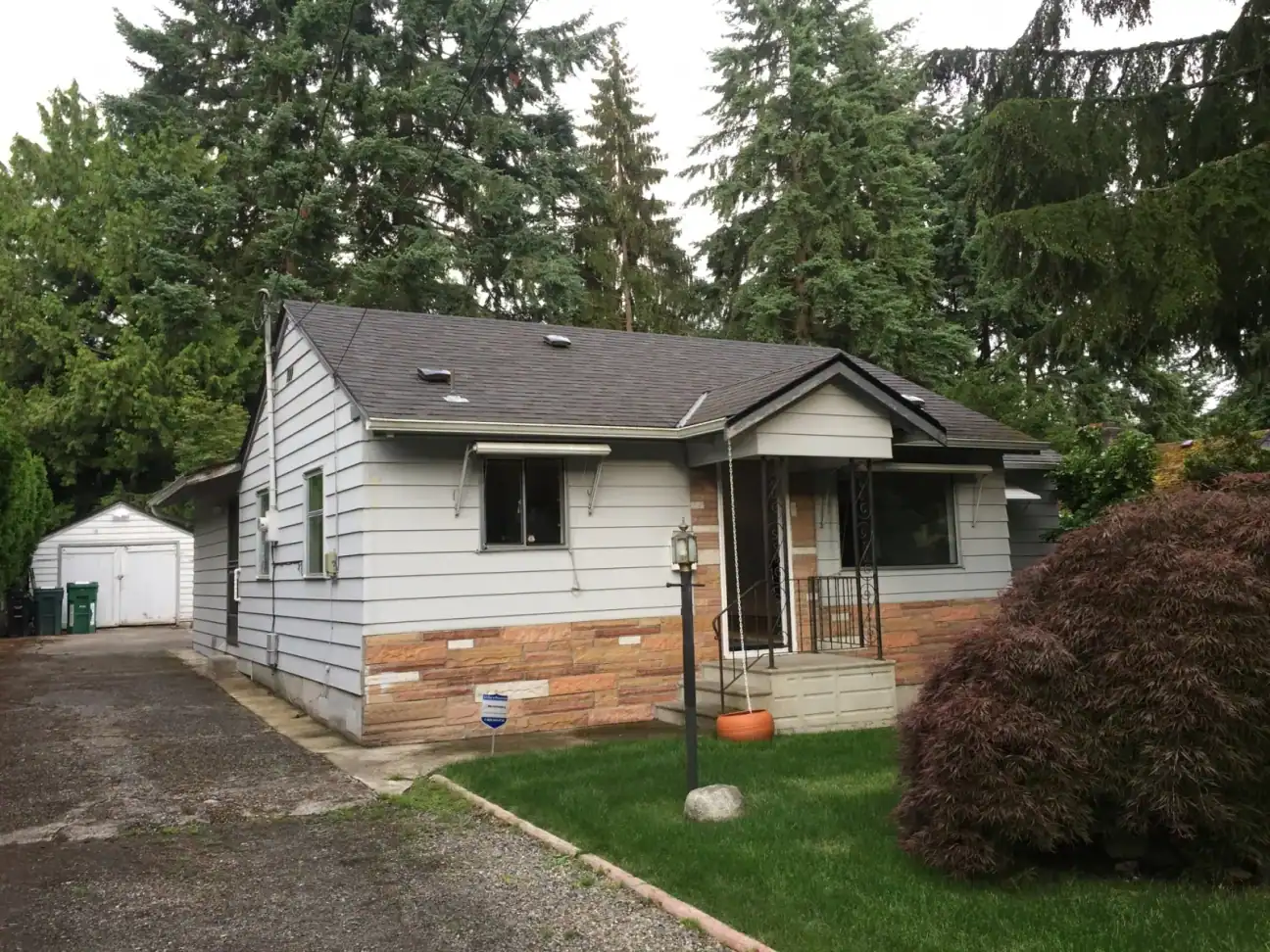 Before: the original 1950s bungalow in Seattle's Broadview neighborhood with gray siding and a brick skirt