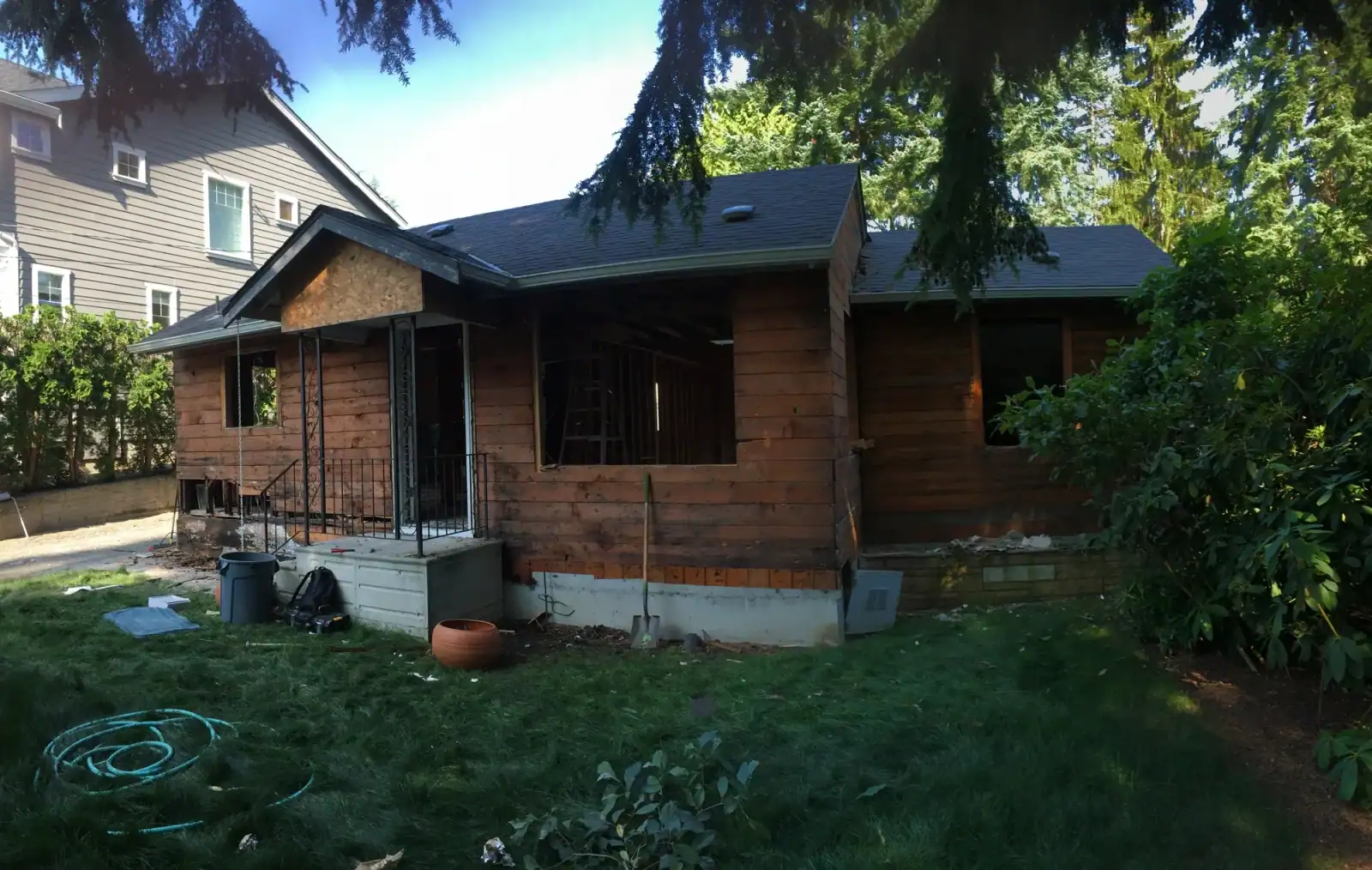 Bungalow stripped of siding and roofing, exposing the old sheathing during demolition