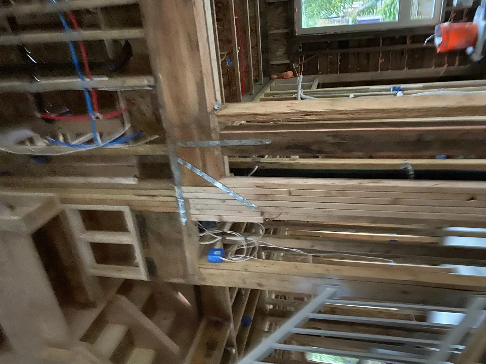 Low-angle framing detail with plumbing and electrical runs between studs