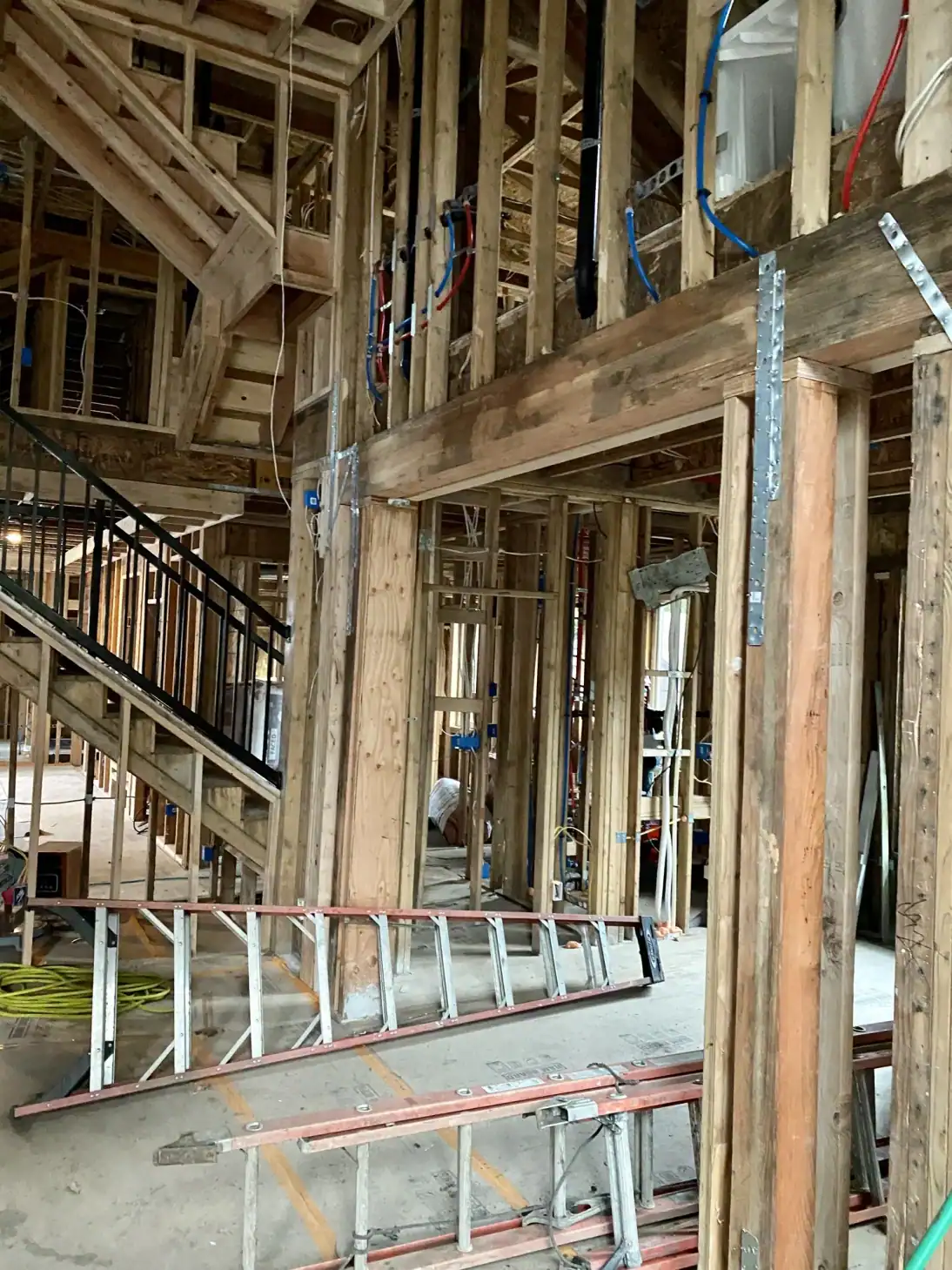 Stairwell framing with ladders ahead of the steel-railed stair install