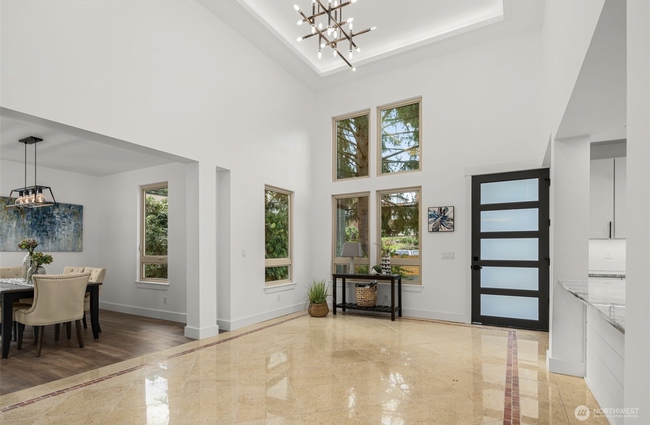 Great room with tall windows, a chandelier, and polished tile floor