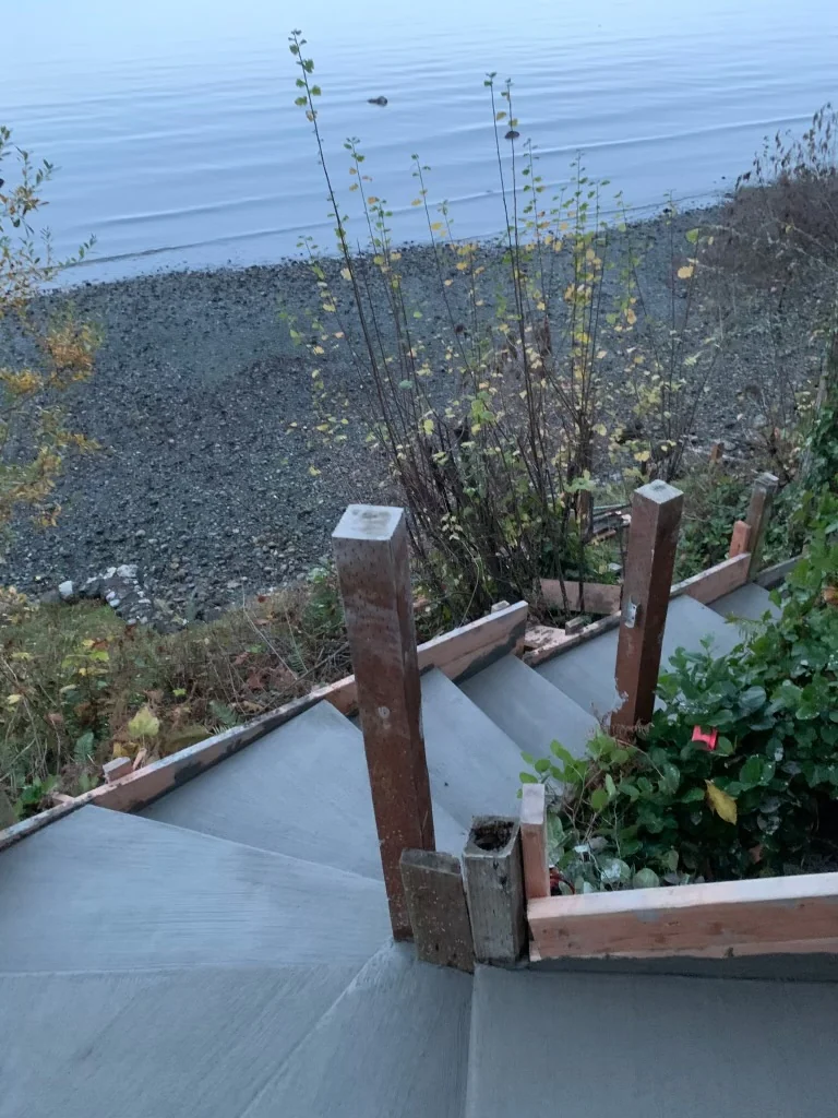 Lower concrete landing above the gravel beach with cedar posts in place