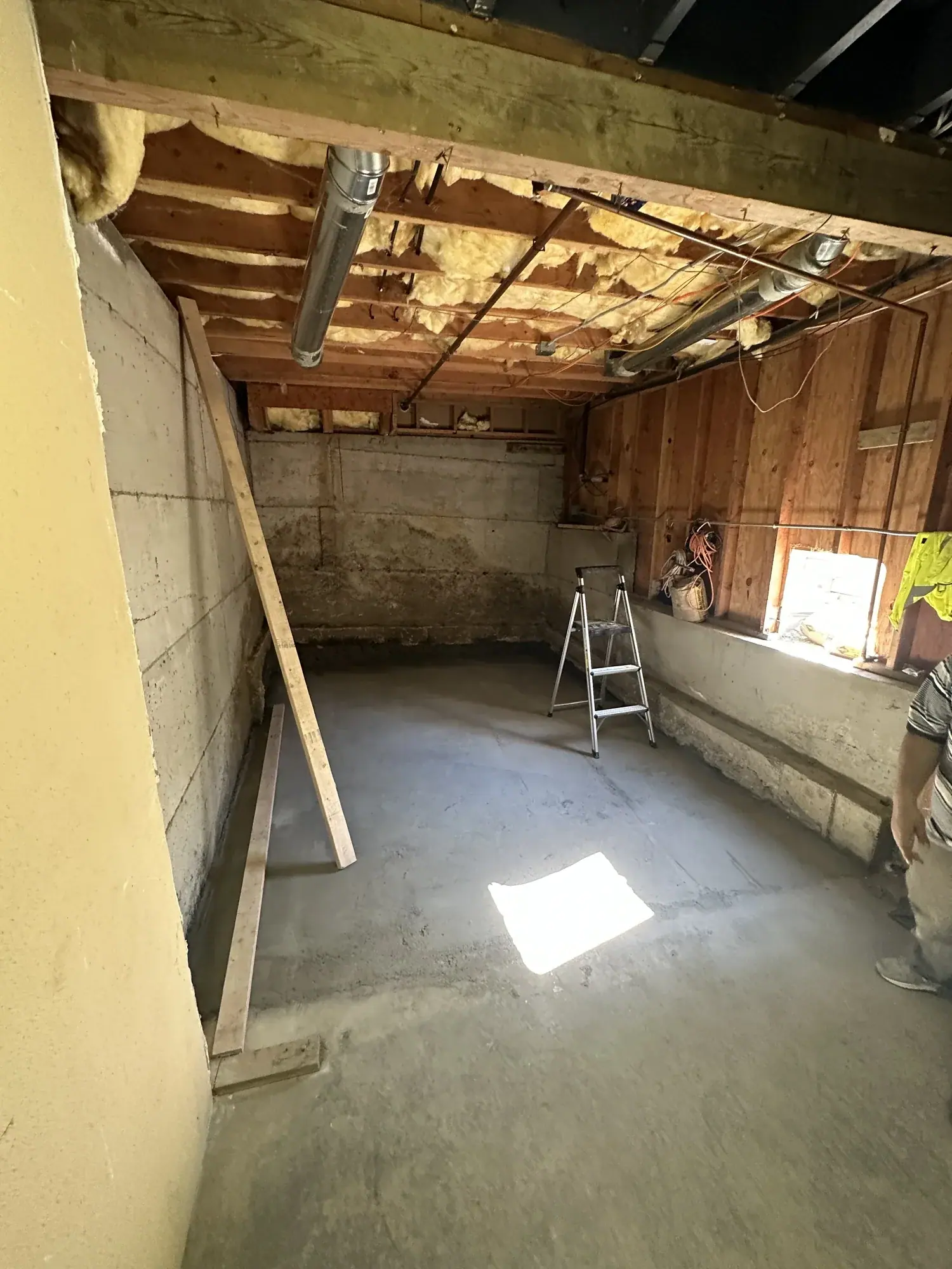 Cured slab and new ceiling framing against the original foundation wall