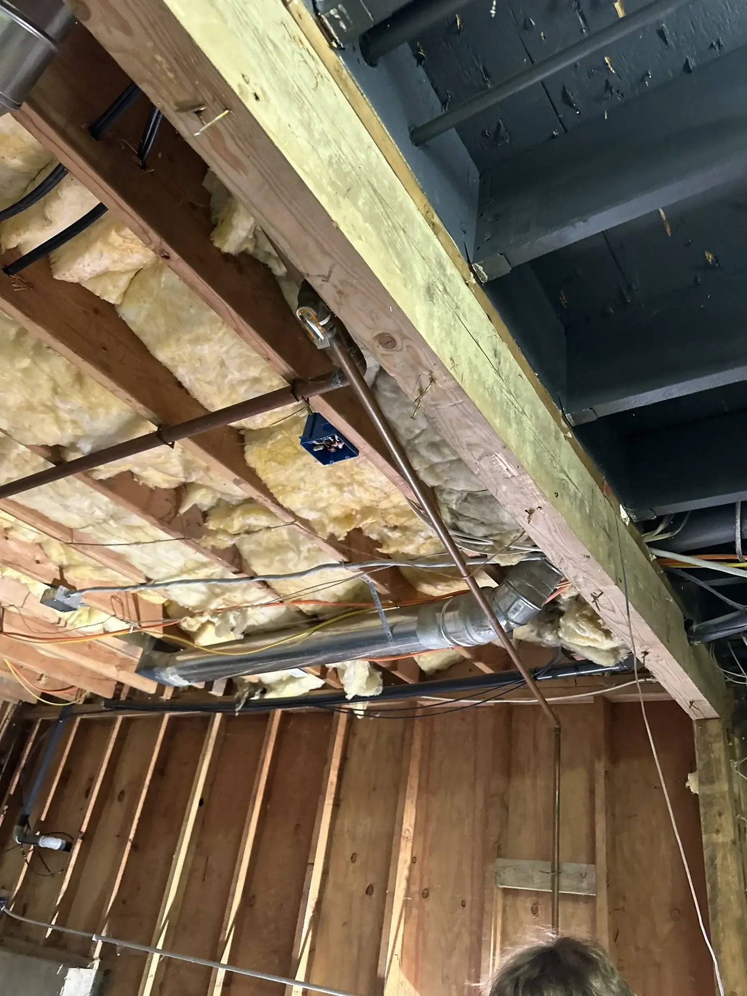 Looking up at ceiling framing with insulation and blocking between joists