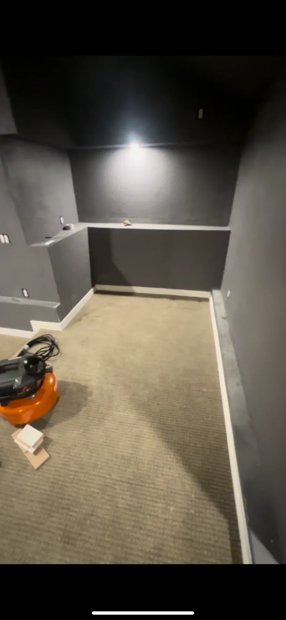 Theater during finish with charcoal walls, white trim, and carpet