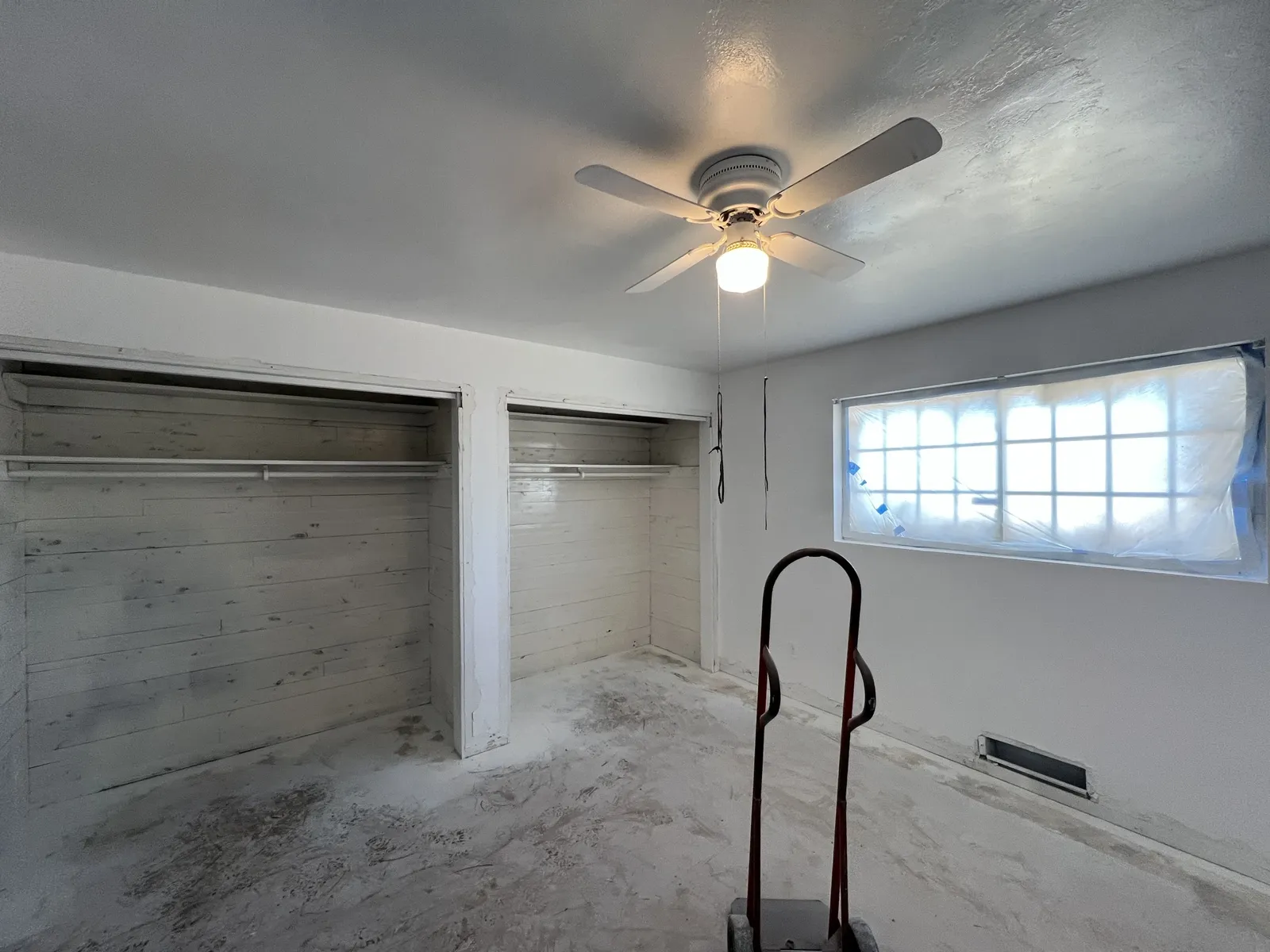 Room mid-remodel with a ceiling fan and old closet doors still in place