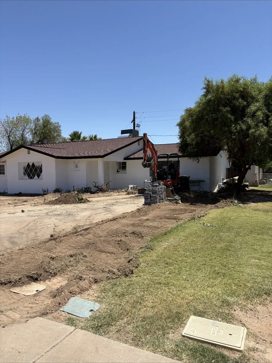 Excavator regrading the front yard beside the house