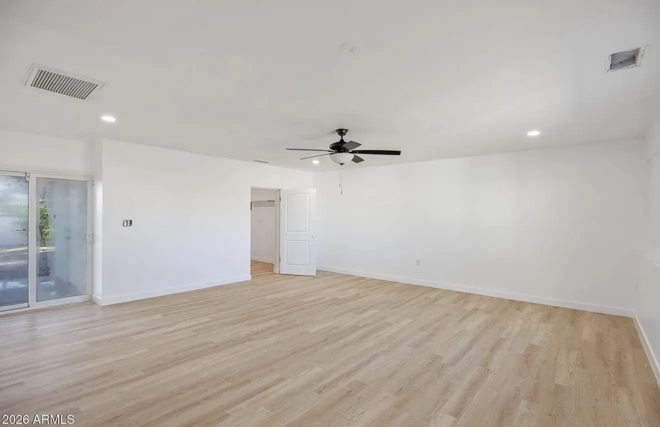 Open living and dining space with LVP flooring, ceiling fan, and sliding door