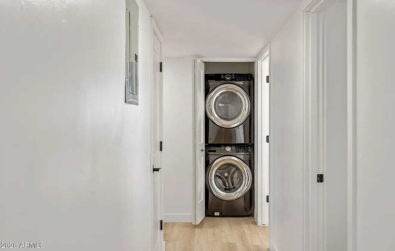 Laundry closet with a stacked washer and dryer behind new doors