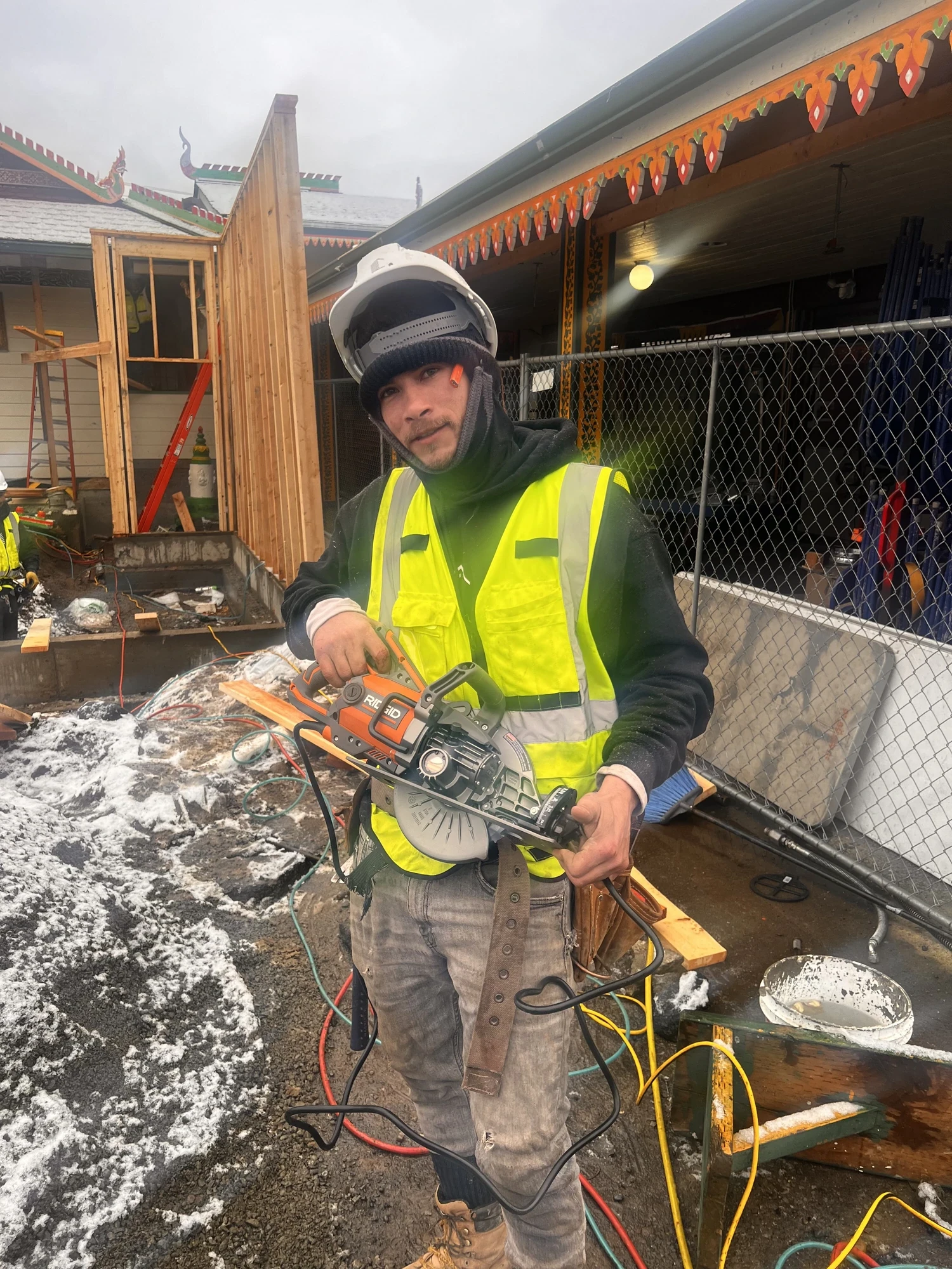 ID Builder Construction crew member cutting with a circular saw on a temple project